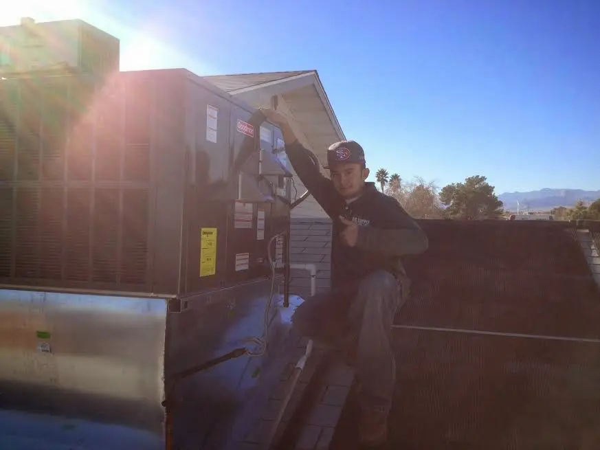 HVAC technician performing Air Duct Cleaning on a rooftop unit in Woodland